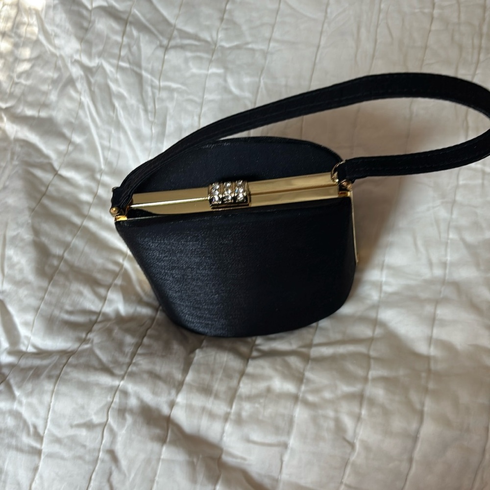 Black evening bag. Comes with chain shoulder strap. New without tag.